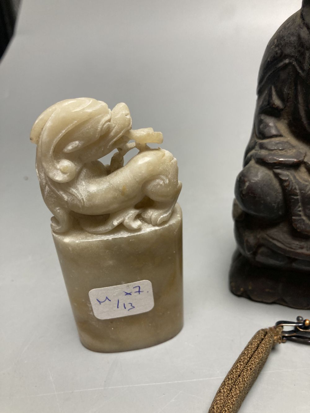 A group of Chinese Works of Art, jades, soapstones, a wooden Buddha and a jade and hair bracelet, tallest 14cm